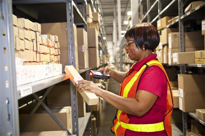 Warehouse employee scanning product barcodes to manage overseas inventory accurately