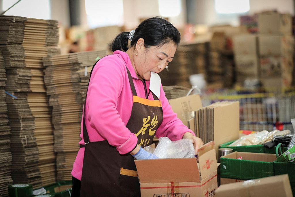 China warehouse worker adding protective packaging before parcel forwarding